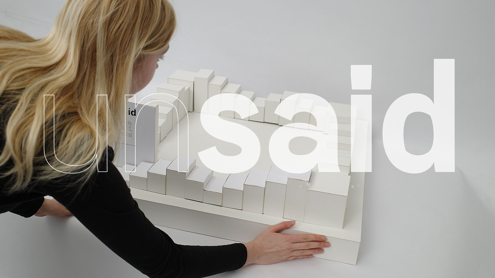 A student is holding the spatial design model of the project 